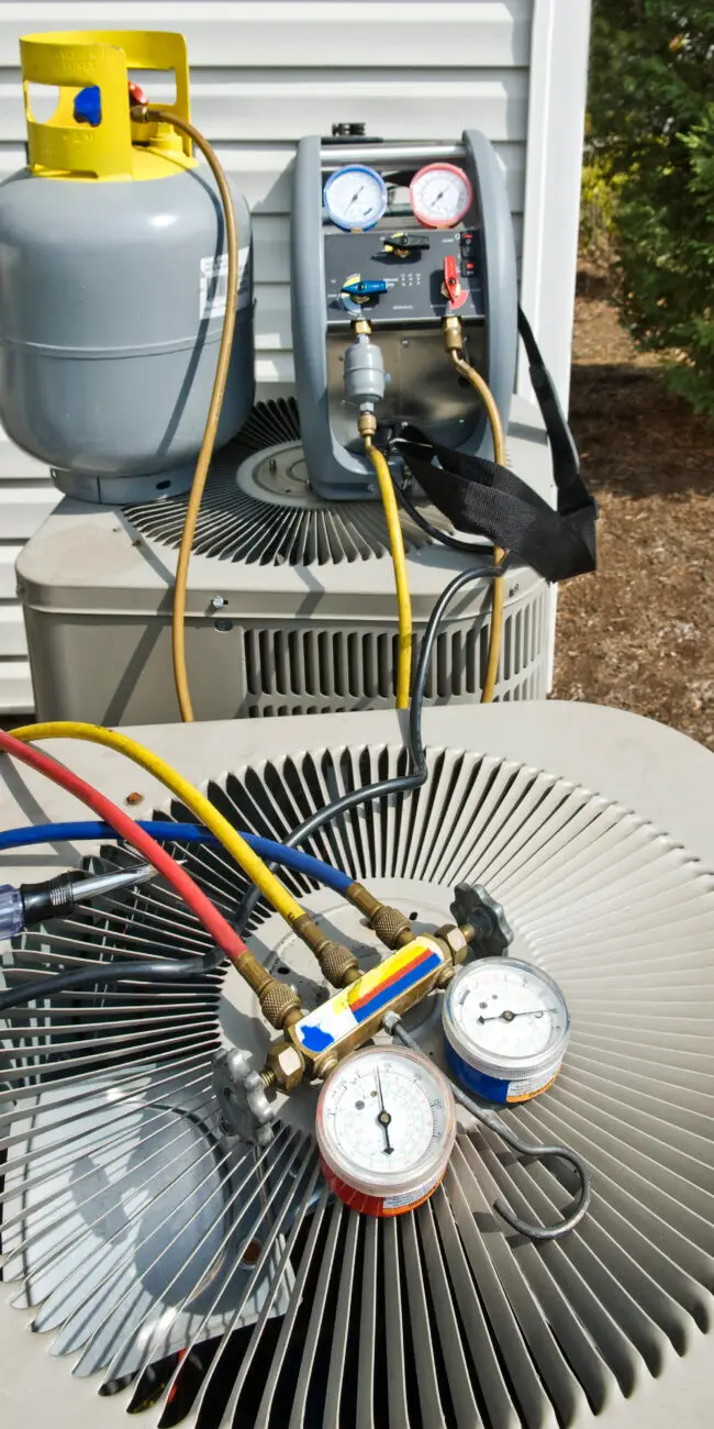 FREEDOM HVAC certified technician servicing an outdoor air conditioning unit at a home in Joplin, MO.
