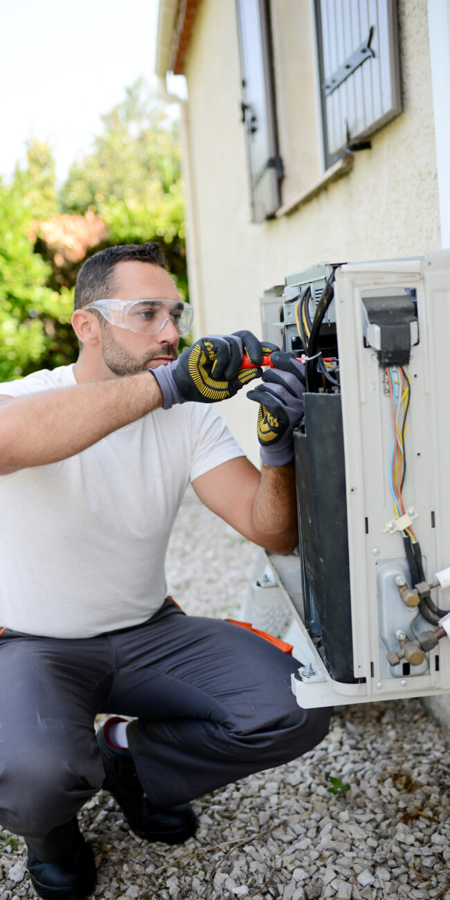 FREEDOM HVAC technicians inspecting a heat pump system at a home near Joplin, Missouri.