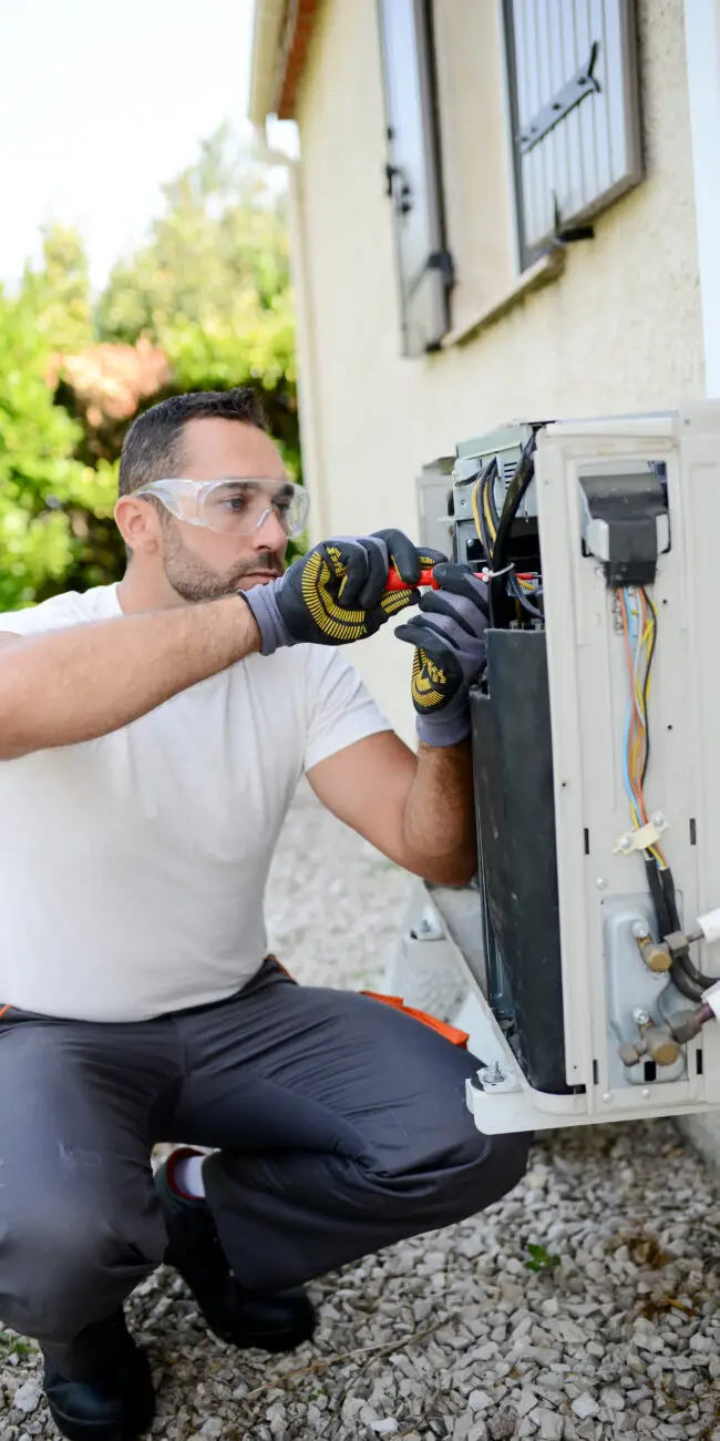 FREEDOM HVAC technicians inspecting a heat pump system at a home near Joplin, Missouri.
