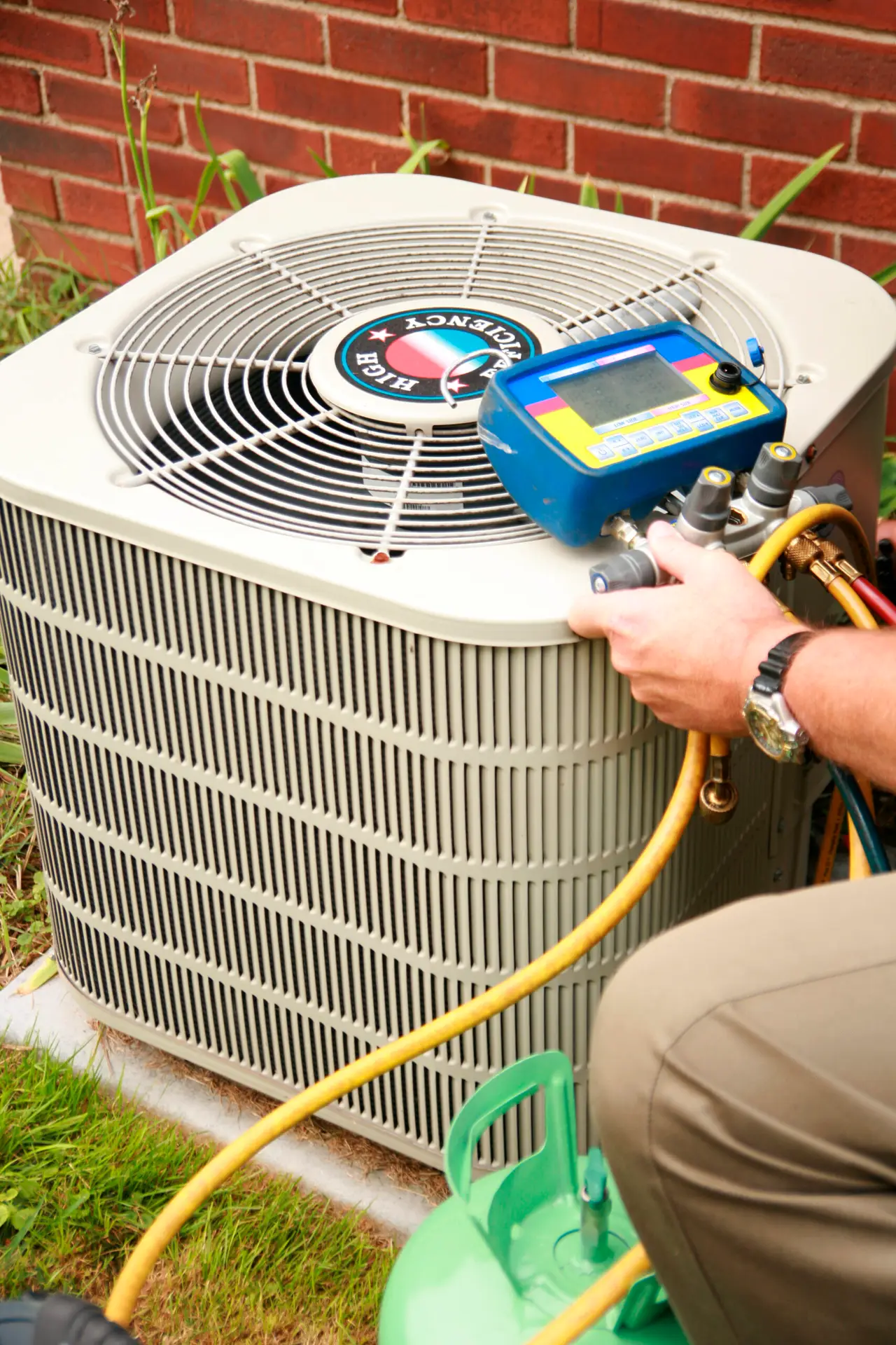 FREEDOM HVAC technician testing refrigerant levels and system efficiency on an outdoor air conditioning unit in Joplin, MO.